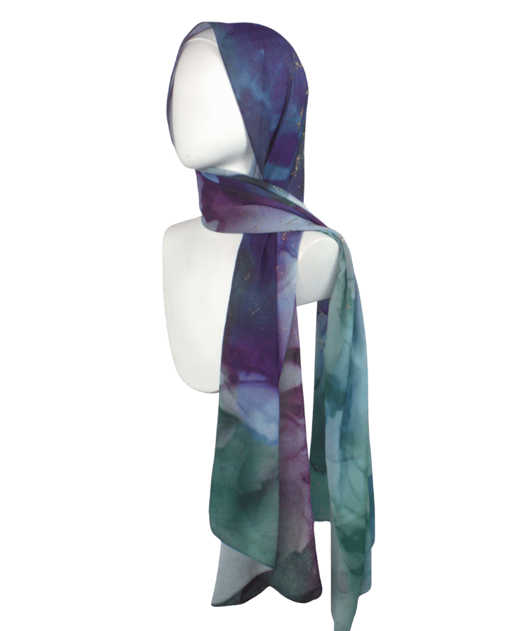 Alt: Designer printed chiffon hijab in blue, green, and purple jewel tones on model.