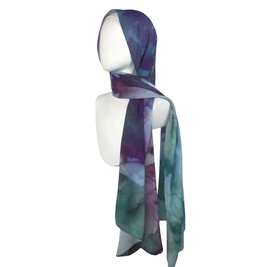 Alt: Designer printed chiffon hijab in blue, green, and purple jewel tones on model.