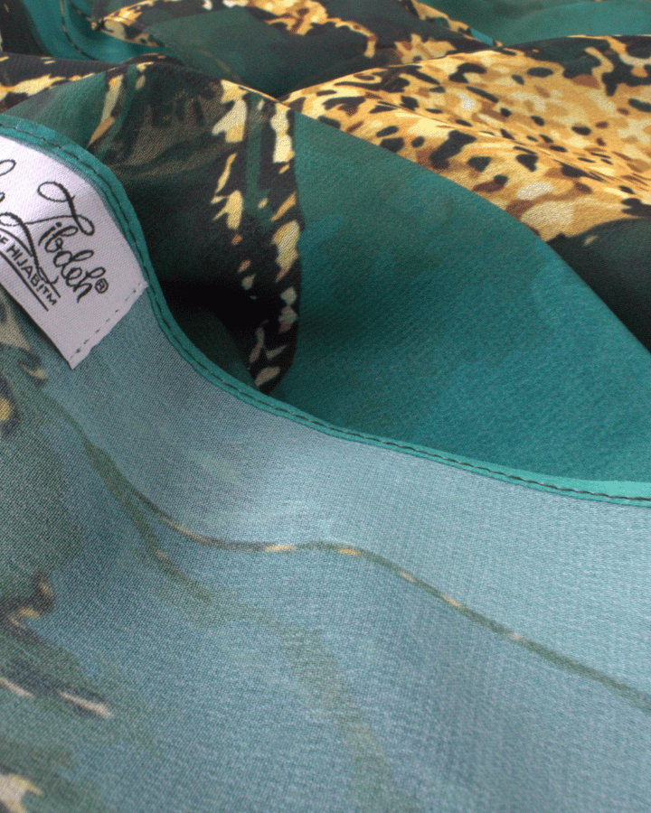 Close-up of premium chiffon fabric highlighting rich emerald color and luxurious texture