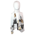 Model wearing a soft white scarf with golden and black floral designs for a sophisticated look.