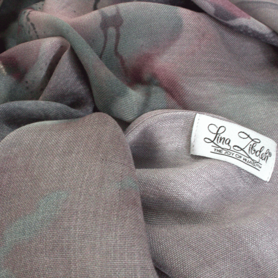 Close-up of a fabric with a visible brand label on a gray background