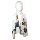 Model wearing a soft white scarf with golden and black floral designs for a sophisticated look.
