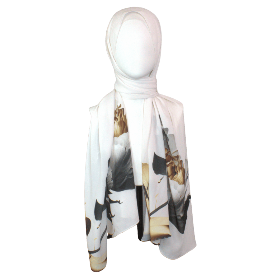 Model wearing a soft white scarf with golden and black floral designs for a sophisticated look.
