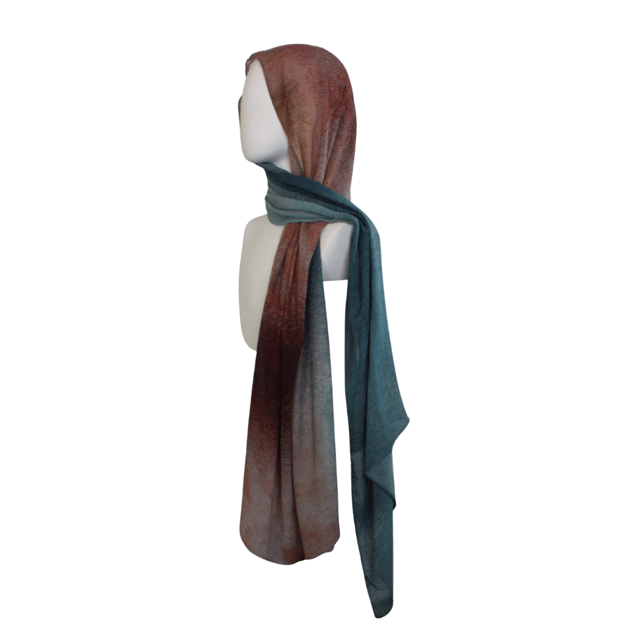 Luxurious Elaris Ombré printed bamboo hijab draped over shoulder, showing teal side | Lina Zibdeh